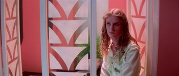 Movie still from “Suspiria” (1977), directed by Dario Argento – A young woman sitting in front of an open window; Medium shot, Low angle