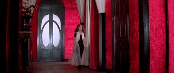 Movie still from “Suspiria” (1977), directed by Dario Argento – A young girl in a black and white dress; Wide shot, Low angle