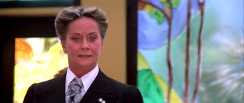 Movie still from “Suspiria” (1977), directed by Dario Argento – A woman wearing a suit and tie standing in front of a stained glass window; Close Up shot, Low angle