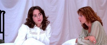Movie still from “Suspiria” (1977), directed by Dario Argento – A young girl sitting in front of a white curtain; Close Up shot, Over the shoulder angle