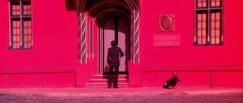 Movie still from “Suspiria” (1977), directed by Dario Argento – A man standing in front of an open door; Wide shot, High angle