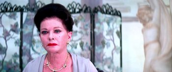 Movie still from “Suspiria” (1977), directed by Dario Argento – An older woman wearing a necklace and earrings; Close Up shot, Over the shoulder angle