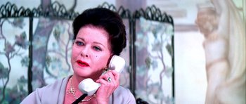 Movie still from “Suspiria” (1977), directed by Dario Argento – An older woman talking on a phone while sitting down; Close Up shot, Low angle