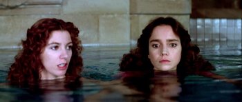 Movie still from “Suspiria” (1977), directed by Dario Argento – Two women are swimming in a pool of water; Close Up shot, High angle
