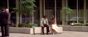 Movie still from “Suspiria” (1977), directed by Dario Argento – A man and a woman sitting on top of a bench; Wide shot, High angle