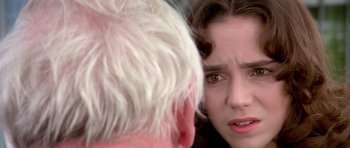 Movie still from “Suspiria” (1977), directed by Dario Argento – A young woman looking at a older man's reflection in a mirror; Close Up shot, Over the shoulder angle