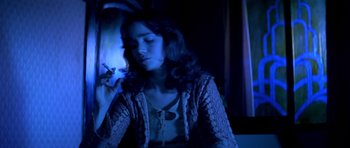 Movie still from “Suspiria” (1977), directed by Dario Argento – A woman sitting in front of a window at night; Medium shot, Low angle