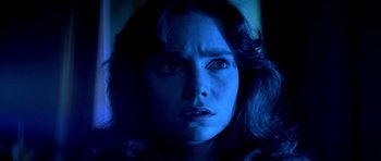 Movie still from “Suspiria” (1977), directed by Dario Argento – A woman's face in blue light; Close Up shot, Low angle