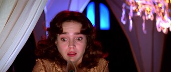 Movie still from “Suspiria” (1977), directed by Dario Argento – A woman with red curly hair is looking surprised; Close Up shot, Low angle
