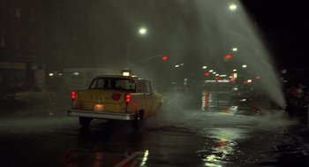 Movie still from “Taxi Driver” (1976), directed by Martin Scorsese – A yellow taxi cab driving down a wet street at night; Extreme Wide shot, Low angle