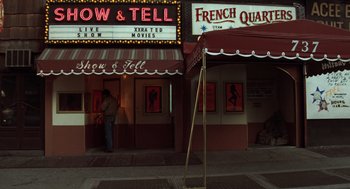 Movie still from “Taxi Driver” (1976), directed by Martin Scorsese – A man standing in front of a movie theater; Wide shot, Low angle
