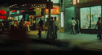 Movie still from “Taxi Driver” (1976), directed by Martin Scorsese – A group of people standing on the side of a street; Wide shot, High angle