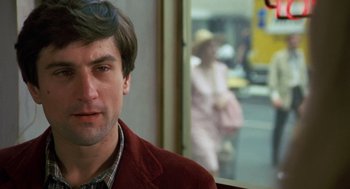 Movie still from “Taxi Driver” (1976), directed by Martin Scorsese – A person wearing a red jacket; Close Up shot, Over the shoulder angle