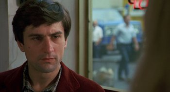 Movie still from “Taxi Driver” (1976), directed by Martin Scorsese – A person wearing a red jacket; Close Up shot, Over the shoulder angle