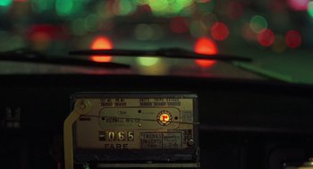 Movie still from “Taxi Driver” (1976), directed by Martin Scorsese – The dashboard of a car with lights in the background; Extreme Close Up shot, Over the shoulder angle