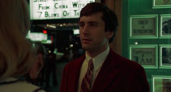 Movie still from “Taxi Driver” (1976), directed by Martin Scorsese – A man in a red jacket and a red tie; Close Up shot, Low angle