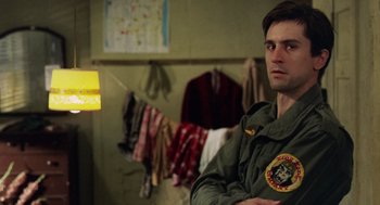 Movie still from “Taxi Driver” (1976), directed by Martin Scorsese – A man in a green jacket in front of a wall; Close Up shot, Over the shoulder angle