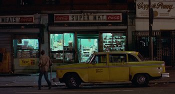 Movie still from “Taxi Driver” (1976), directed by Martin Scorsese – A yellow taxi cab parked in front of a store; Wide shot, Low angle