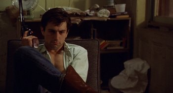 Movie still from “Taxi Driver” (1976), directed by Martin Scorsese – A man sitting in a chair with his arm in a cast; Close Up shot, Low angle