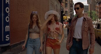 Movie still from “Taxi Driver” (1976), directed by Martin Scorsese – A group of people walking down a street; Medium shot, Low angle