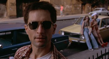 Movie still from “Taxi Driver” (1976), directed by Martin Scorsese – A person wearing sunglasses on the street; Close Up shot, Low angle