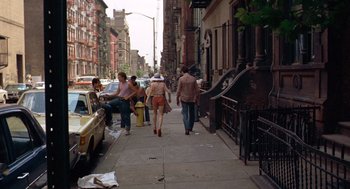 Movie still from “Taxi Driver” (1976), directed by Martin Scorsese – A group of people walking down a sidewalk; Wide shot, Over the shoulder angle