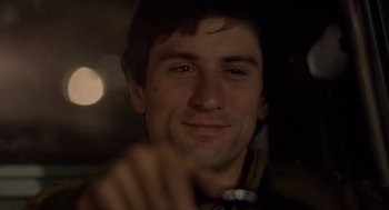 Movie still from “Taxi Driver” (1976), directed by Martin Scorsese – A young man's face in the dark; Close Up shot, Over the shoulder angle