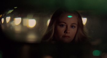 Movie still from “Taxi Driver” (1976), directed by Martin Scorsese – A woman looking at the camera in a car; Close Up shot, Low angle