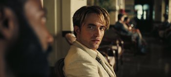 Movie still from “Tenet” (2020), directed by Christopher Nolan – A person wearing a suit and tie; Close Up shot, Over the shoulder angle