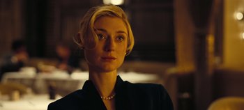 Movie still from “Tenet” (2020), directed by Christopher Nolan – A woman in a black jacket and a pearl necklace; Close Up shot, Low angle