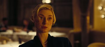 Movie still from “Tenet” (2020), directed by Christopher Nolan – A woman with blonde hair wearing a black jacket; Close Up shot, Low angle