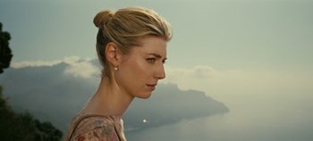 Movie still from “Tenet” (2020), directed by Christopher Nolan – A beautiful woman with a bun in front of a cloudy sky; Close Up shot, Low angle