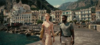 Movie still from “Tenet” (2020), directed by Christopher Nolan – A man and a woman walking down a street; Medium shot, Low angle