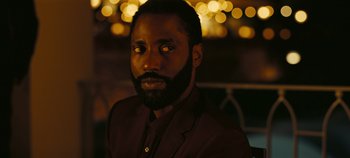 Movie still from “Tenet” (2020), directed by Christopher Nolan – A man with a beard is wearing a suit and tie; Close Up shot, High angle