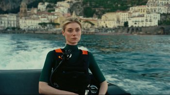 Movie still from “Tenet” (2020), directed by Christopher Nolan – A woman sitting on the back of a boat in the water; Medium shot, Low angle