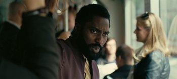 Movie still from “Tenet” (2020), directed by Christopher Nolan – A man with a beard and a tie on; Close Up shot, Over the shoulder angle