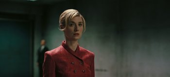 Movie still from “Tenet” (2020), directed by Christopher Nolan – A woman in a red jacket is looking at the camera; Close Up shot, Low angle