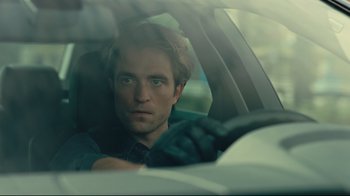 Movie still from “Tenet” (2020), directed by Christopher Nolan – A man sitting in the driver's seat of a car; Close Up shot, Over the shoulder angle