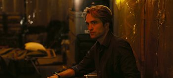 Movie still from “Tenet” (2020), directed by Christopher Nolan – A person sitting at a table; Close Up shot, High angle