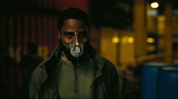 Movie still from “Tenet” (2020), directed by Christopher Nolan – A man with a gas mask is standing in the dark; Close Up shot, Low angle