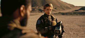Movie still from “Tenet” (2020), directed by Christopher Nolan – A man holding a video camera in his hands; Close Up shot, Over the shoulder angle