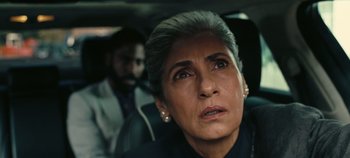 Movie still from “Tenet” (2020), directed by Christopher Nolan – An older woman in the back seat of a car; Close Up shot, Low angle