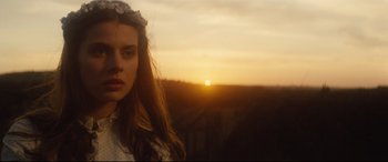 Movie still from “Tess” (1979), directed by Roman Polanski – A woman in a white dress is looking at the camera; Close Up shot, Low angle