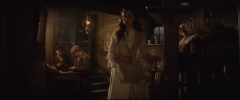 Movie still from “Tess” (1979), directed by Roman Polanski – A woman in a white dress standing next to a man; Wide shot, Low angle