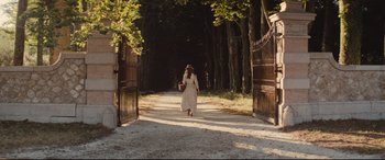 Movie still from “Tess” (1979), directed by Roman Polanski – A woman in a white dress walking down a path; Wide shot, Over the shoulder angle
