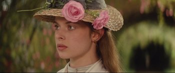 Movie still from “Tess” (1979), directed by Roman Polanski – A woman wearing a straw hat with pink flowers on top of her head; Close Up shot, Over the shoulder angle