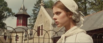 Movie still from “Tess” (1979), directed by Roman Polanski – A woman in a white dress and a white hat; Close Up shot, Low angle