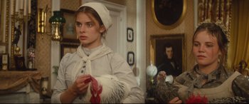 Movie still from “Tess” (1979), directed by Roman Polanski – A woman in a white dress holding a turkey in a room; Close Up shot, Low angle