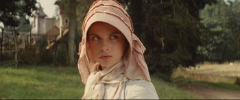 Movie still from “Tess” (1979), directed by Roman Polanski – A young woman wearing a pink hat and a white dress; Close Up shot, Low angle