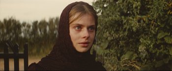 Movie still from “Tess” (1979), directed by Roman Polanski – A young woman wearing a black hooded scarf; Close Up shot, Over the shoulder angle